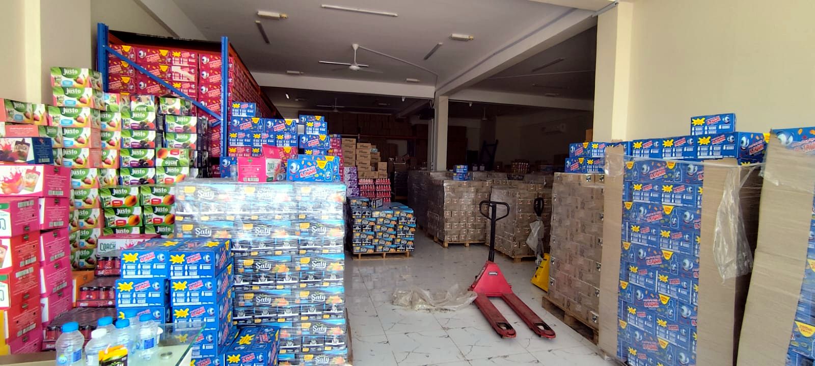 Pallets of drinks and a pallet truck in the Baraka International warehouse